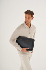 Profile view of model wearing the Oroton Lucas 13" Satchel in Black and Pebble Leather for Men