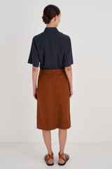 Profile view of model wearing the Oroton Utility Skirt in Tan and 100% Cotton for Women