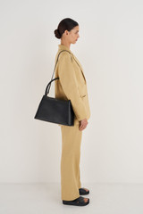 Profile view of model wearing the Oroton Muse Day Bag in Black and Saffiano / Smooth Leather for Women