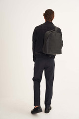 Profile view of model wearing the Oroton Liam Backpack in Black and Smooth Leather for Men