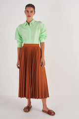 Profile view of model wearing the Oroton Pleat Skirt in Brandy and 65% Polyester, 35% Cotton for Women