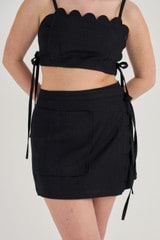 Profile view of model wearing the Oroton Linen Wrap Skirt in Black and 100% Linen for Women
