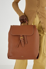 Profile view of model wearing the Oroton Margot Large Backpack in Whiskey and Pebble Leather for Women