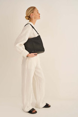 Profile view of model wearing the Oroton Tessa Hobo in Black/Silver and Pebble Leather for Women