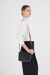 Profile view of model wearing the Oroton Harriet Crossbody in Black and Saffiano Leather With Smooth Leather Trim for Women