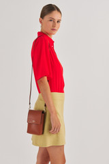 Profile view of model wearing the Oroton Harriet Phone Crossbody in Cognac and Saffiano Leather for Women