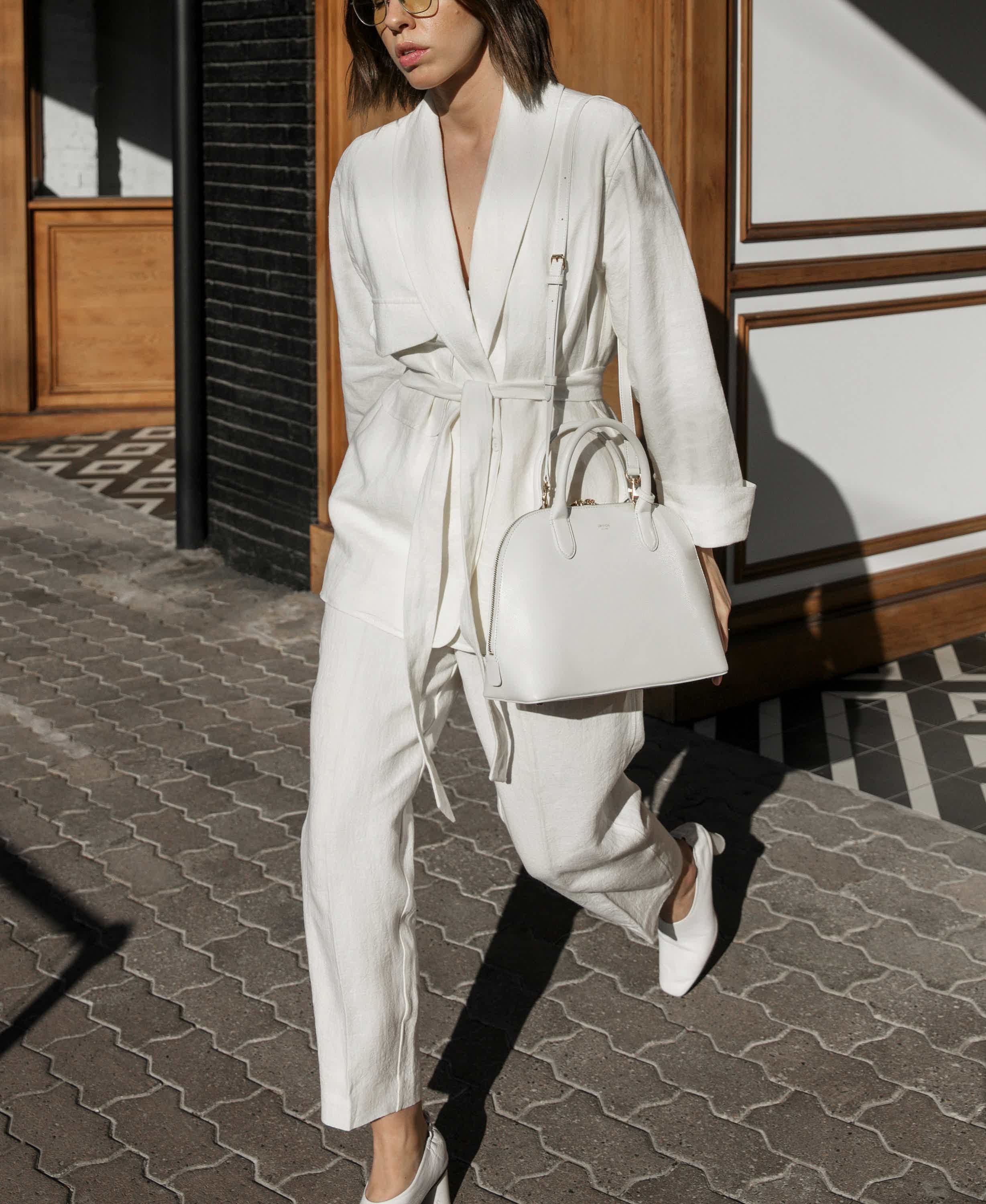 Kaity Modern in  an Oroton Linen Blazer with White grip top bag 